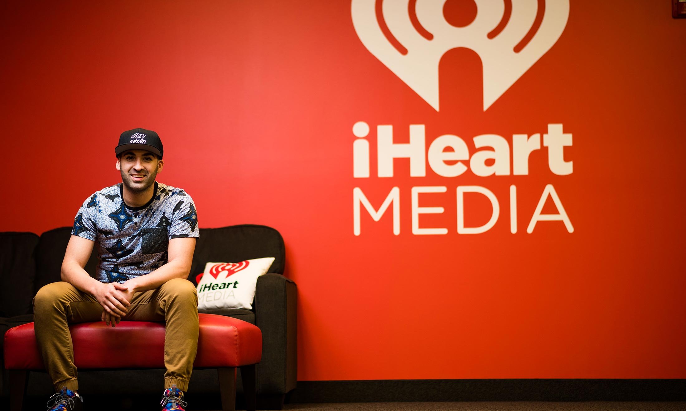 Joe Namou rests on a couch at the entrance of the iHeartRadio studio 