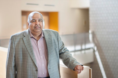 Ravi Parameswaran, Ph.D. leaning against a railing at the top of a stairway