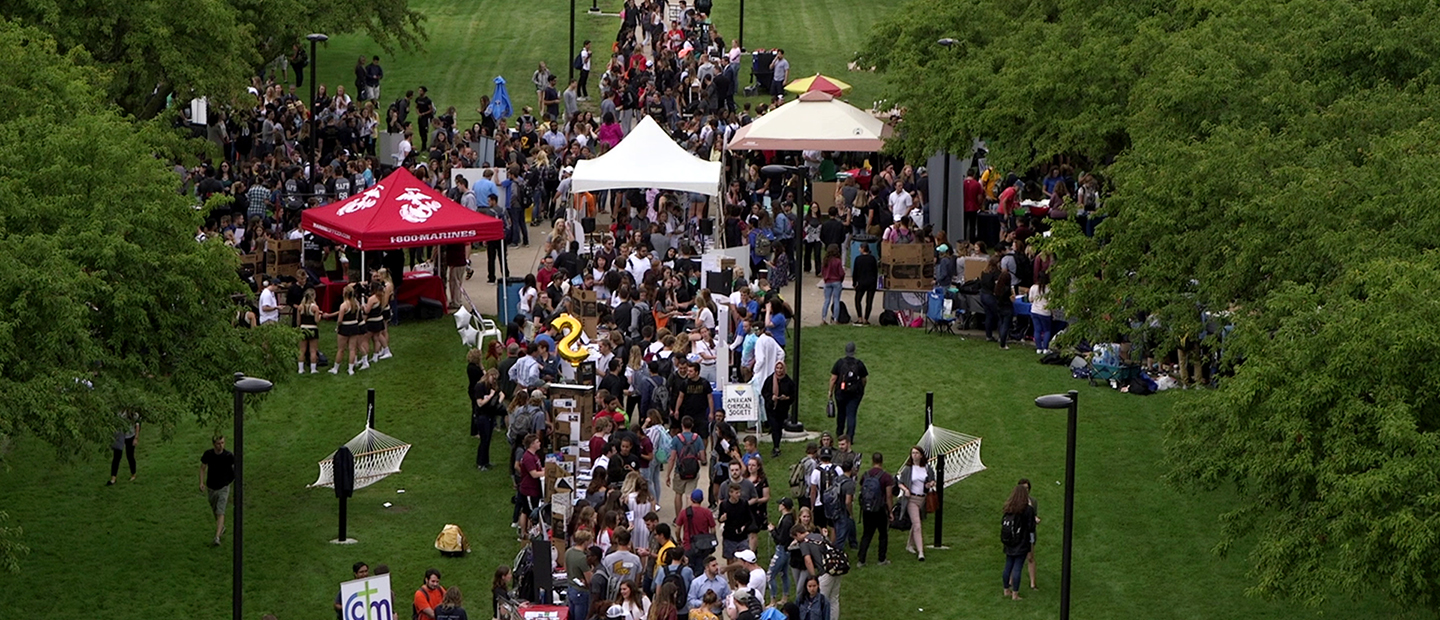 aerial view image of crowds of students and tents surrounded by trees