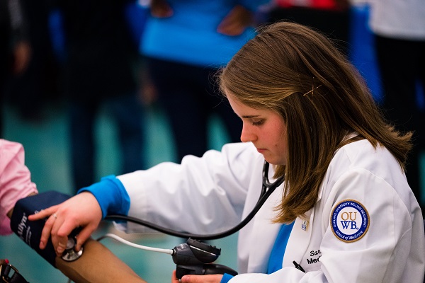 An OUWB student takes someone's blood pressure at the annual Health Fair and Taste Test