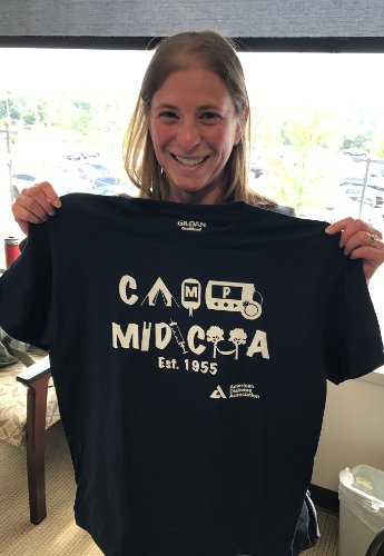 Medical student holding up "Camp Midicha" t-shirt