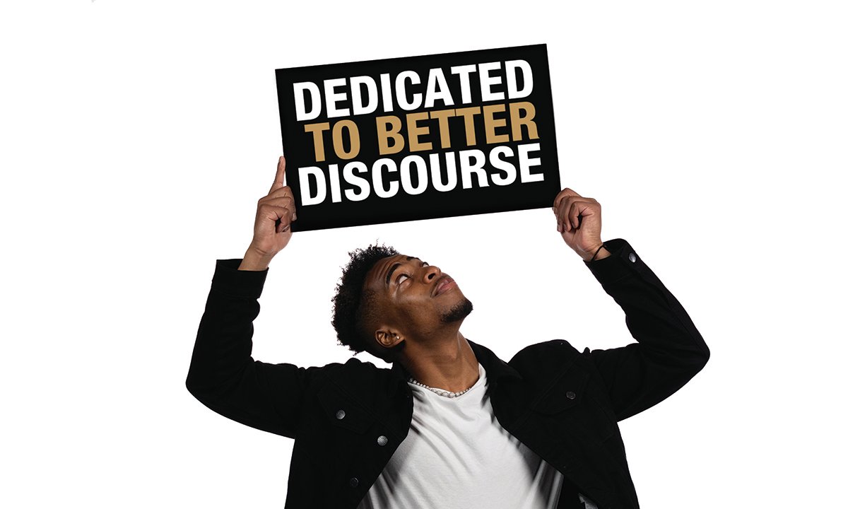 Man holding up sign with "Dedicated to Better Discourse"