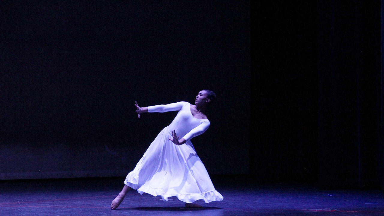Woman in white dance outfit on stage