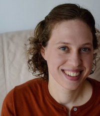 woman in a red shirt smiling at the camera