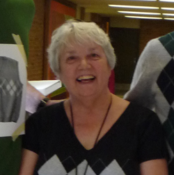 woman in a black and white shirt smiling at the camera
