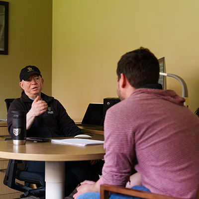 An adviser and a student talking in an office.
