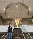 Tressa Palomba standing in front of a golden staircase