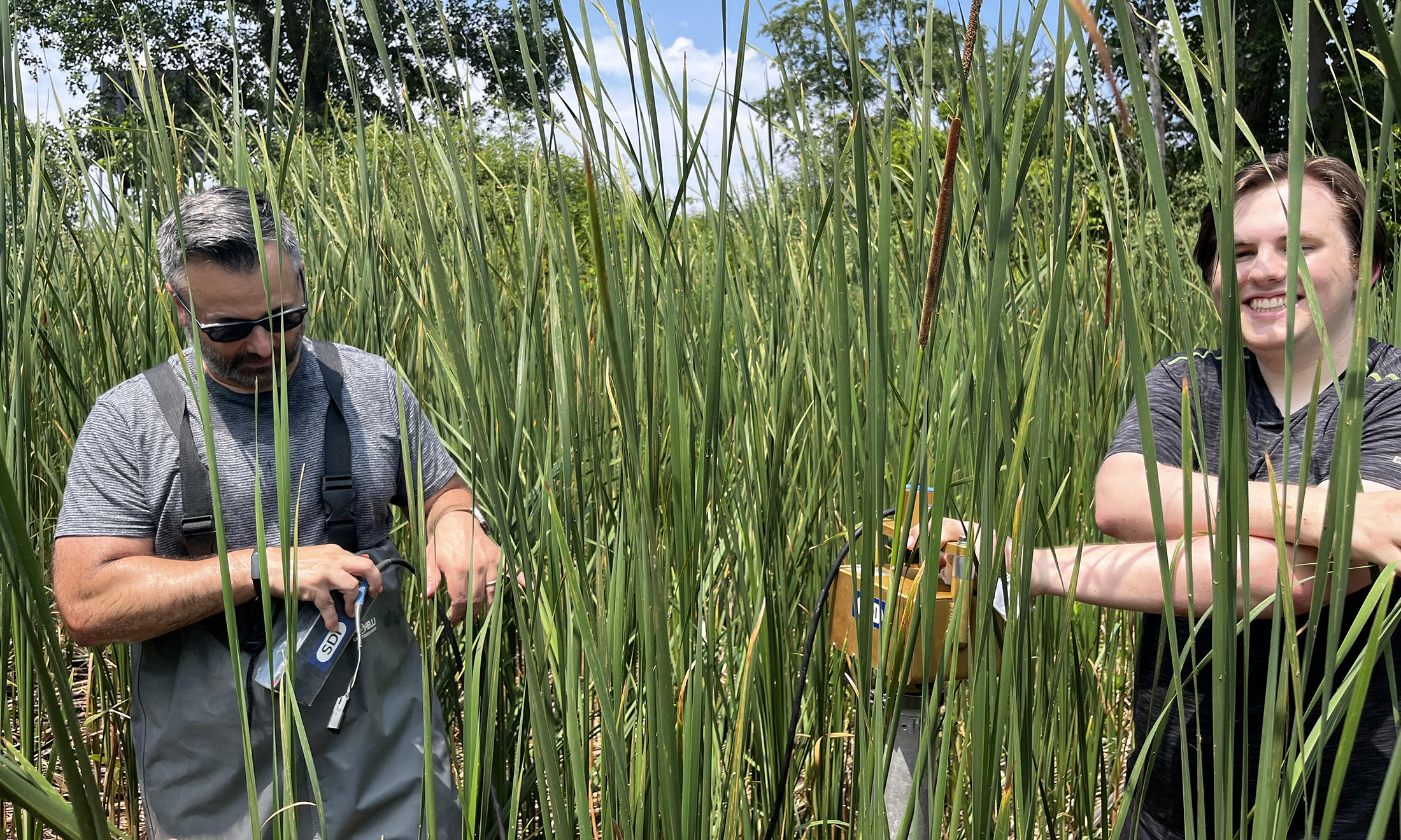 Assistant Professor in the Department of Chemistry Thomas Bianchette (left) works in the field with a student.