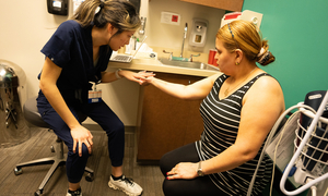A student looks at a patient's arm