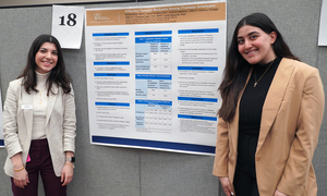 Two students standing in front of their research poster