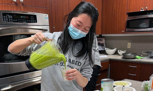 A student pours a smoothie out of a blender