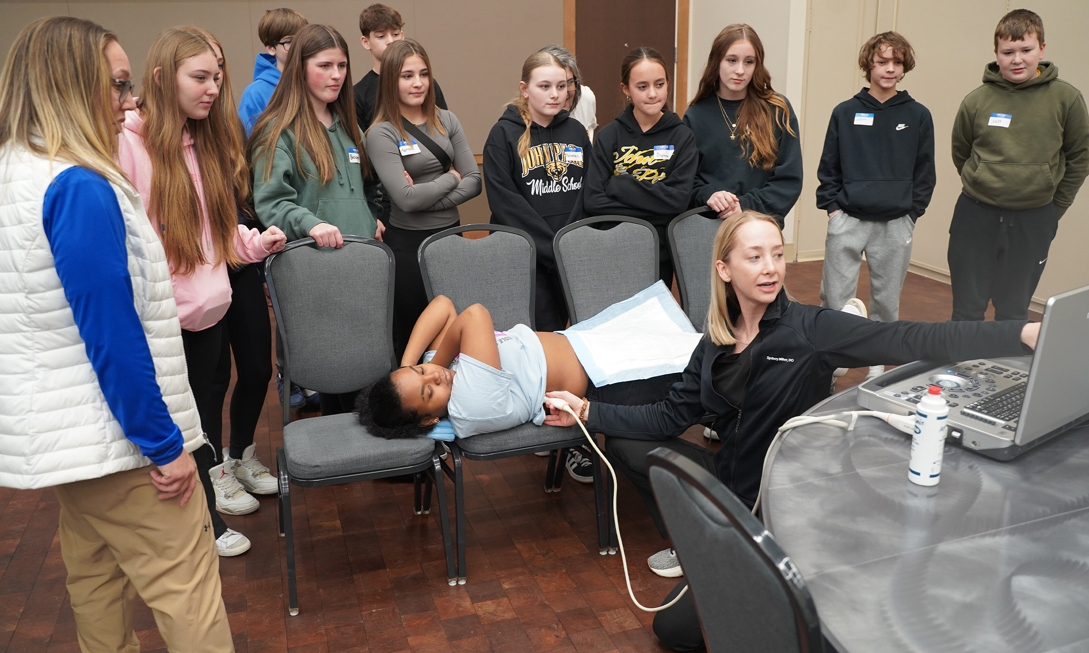 Young students watch a doctor use a portable ultrasound