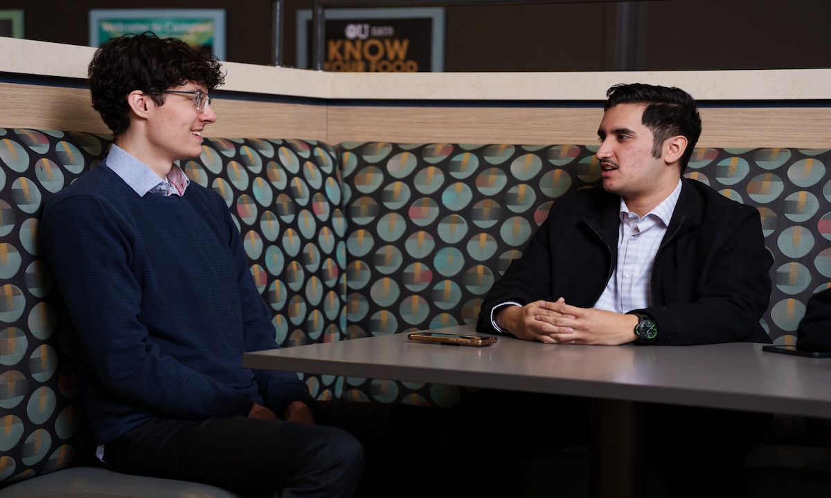 Two students sitting at a table talking