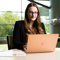 Woman works on a laptop.
