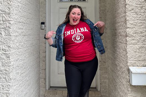 A woman smiling in front of a door.