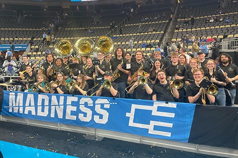 Band poses at a sports stadium.