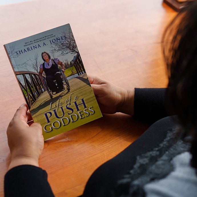 A person holding a book titled 