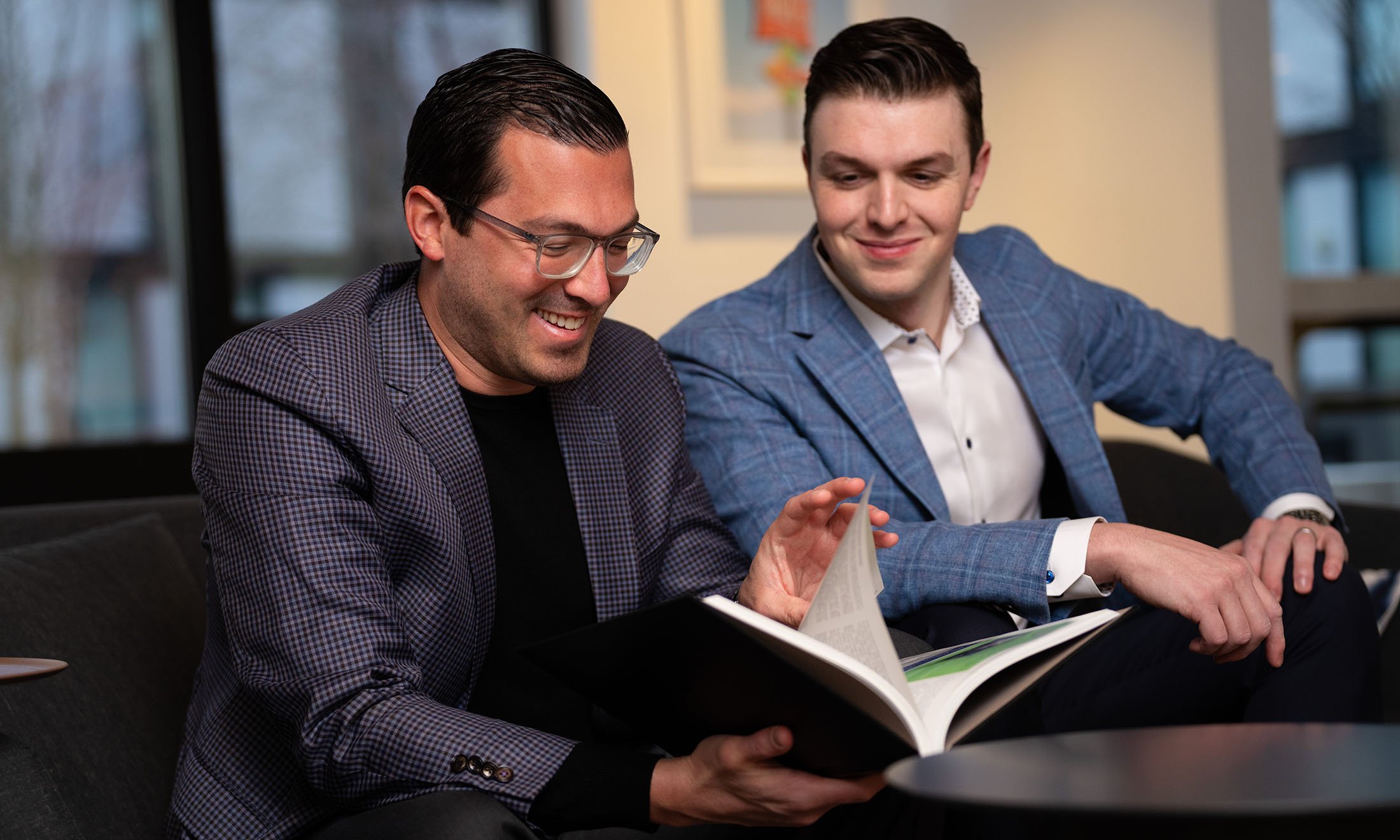Two people sitting together looking through book