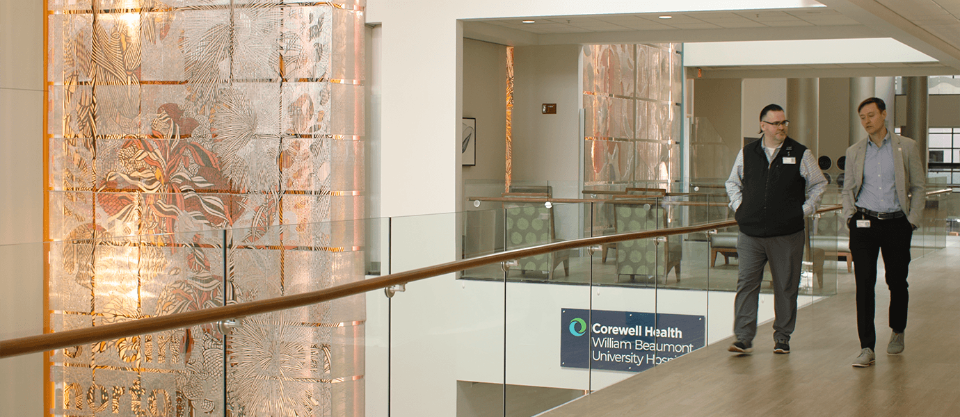 Two men walking down hallway in hospital