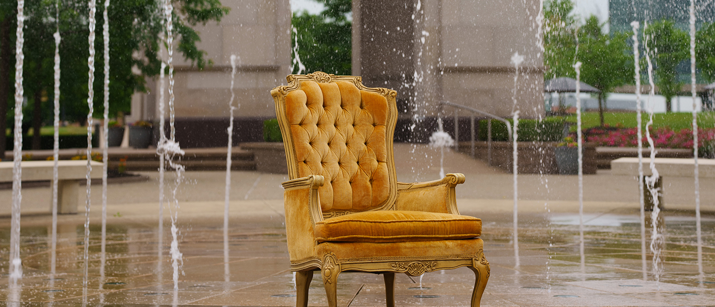 A gold seat in front of a fountain
