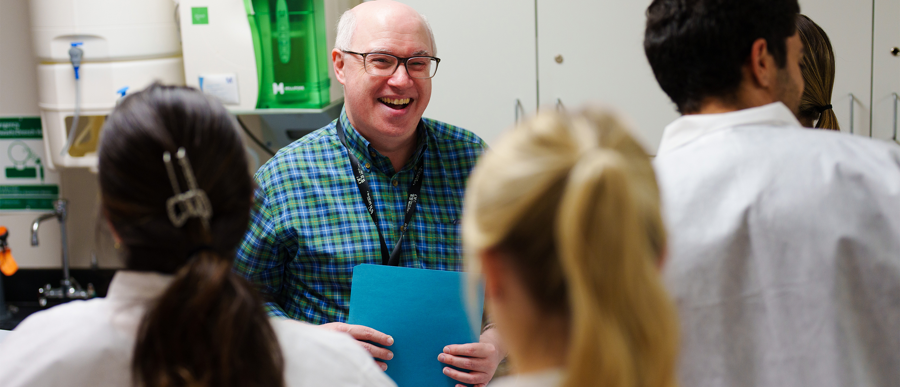 An image of a faculty member and students