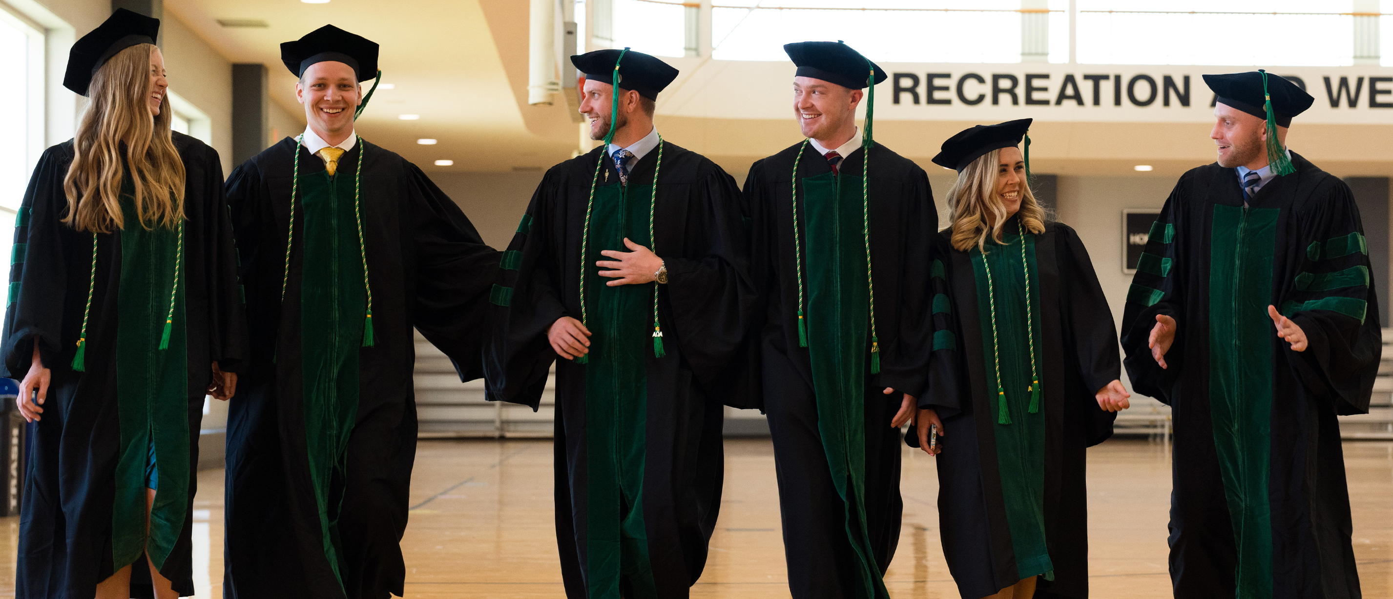 An image of a student and OUWB officials at white coat