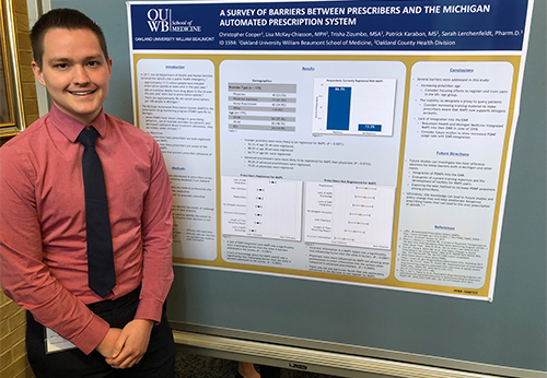 An image of a student by a poster