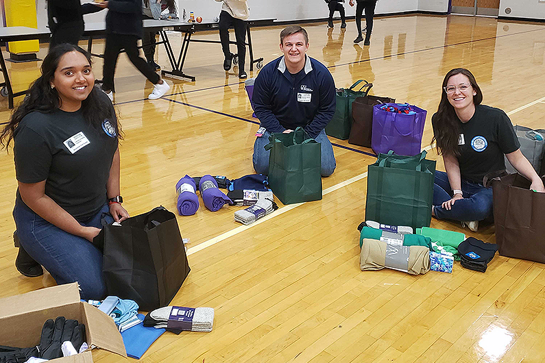 An image of students sitting on a gym floor