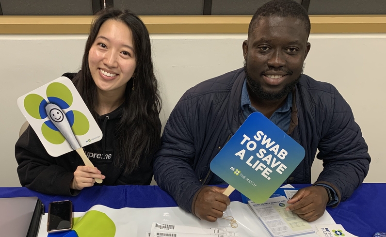 An image of two students holding signs