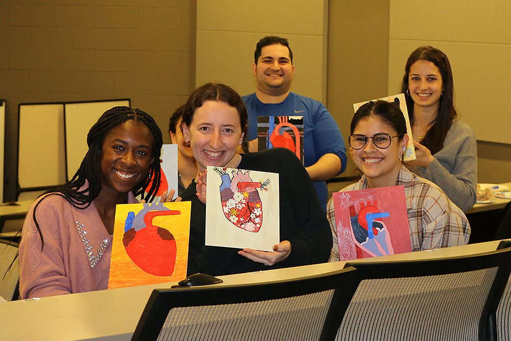 An image of students holding artwork