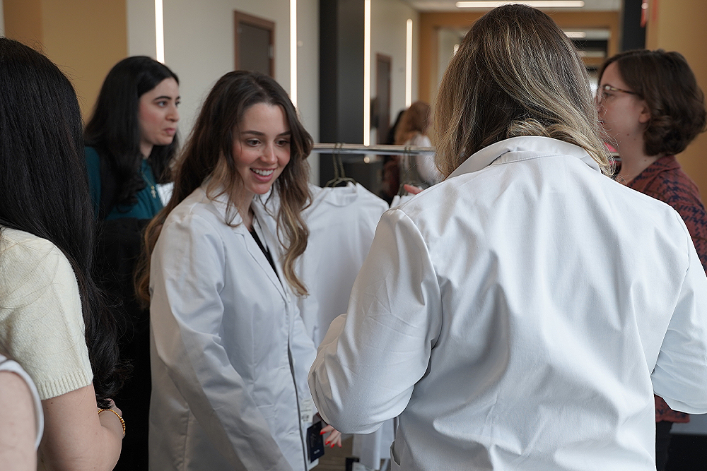 An image of admitted students trying out white coats