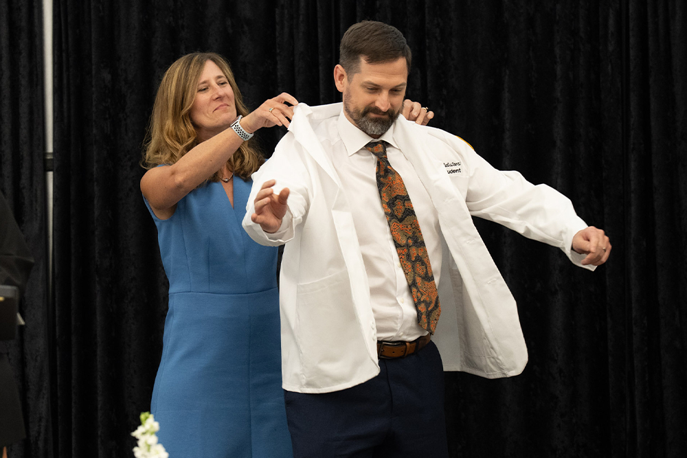 An image of a student receiving his white coat