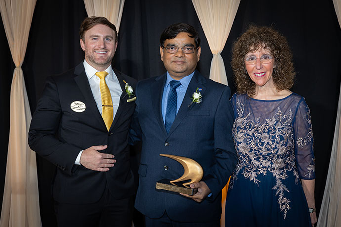 three people posing with the awards