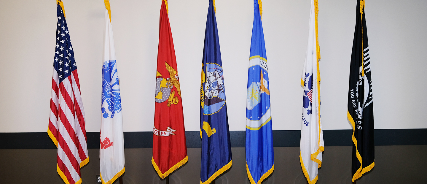 American and armed forces flags on flag poles